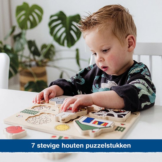 Een jongen met blond haar speelt met een houten vormpuzzel met boerderijdieren.