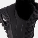 Detailopname van de zwarte Skechers Uno Rugged met imitatiebont en zichtbare Air-unit in de zool.