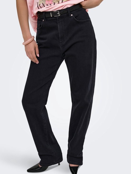 Focus op de zwarte jeans met een zwarte riem, gedragen met een roze T-shirt.