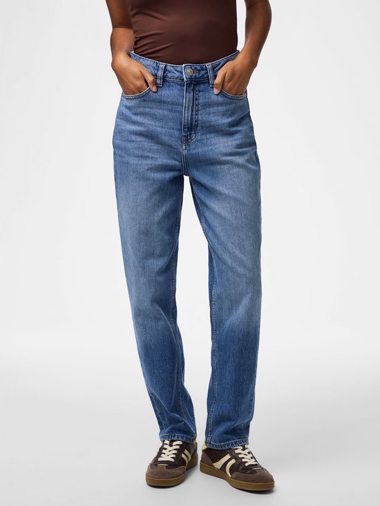 Model draagt een blauwe jeans met rechte pasvorm en hoge taille, gecombineerd met een bruin shirt en sneakers.