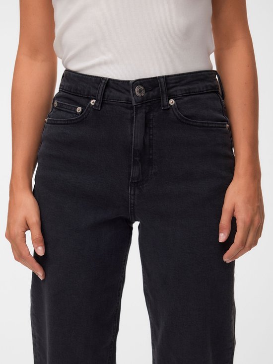 Close-up van de taille en zakken van de zwarte mom-fit jeans met metalen knoop.