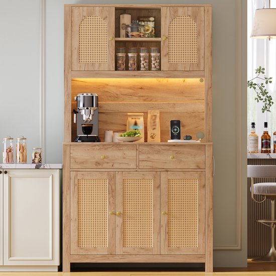 Naturelkleurige keukenkast met 2 lades en 5 deuren met rattan-inzetstukken, gevuld met keukengerei en apparaten.