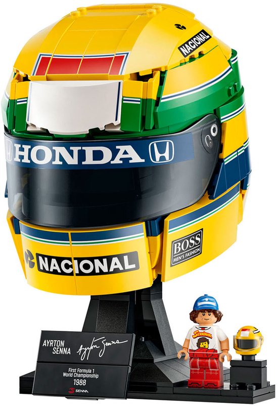 Casque LEGO détaillé d'Ayrton Senna, jaune, vert et bleu, avec logos Honda et Nacional sur un présentoir.