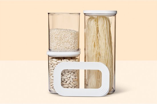 Trois boîtes de conservation Mepal Modula remplies de riz, de haricots blancs et de spaghettis. Un couvercle blanc est placé devant.