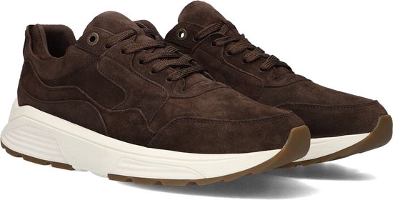 Schuin vooraanzicht van een paar donkerbruine suède sneakers met witte zool en bruine accenten.