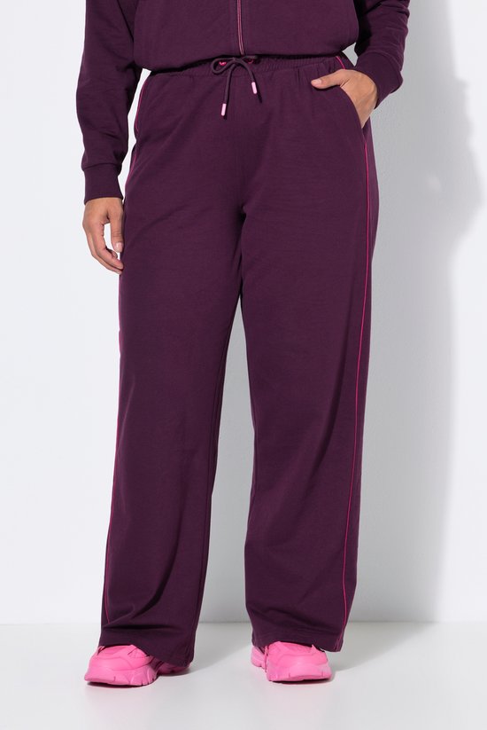 Model in donkerpaarse joggingbroek met roze bies.