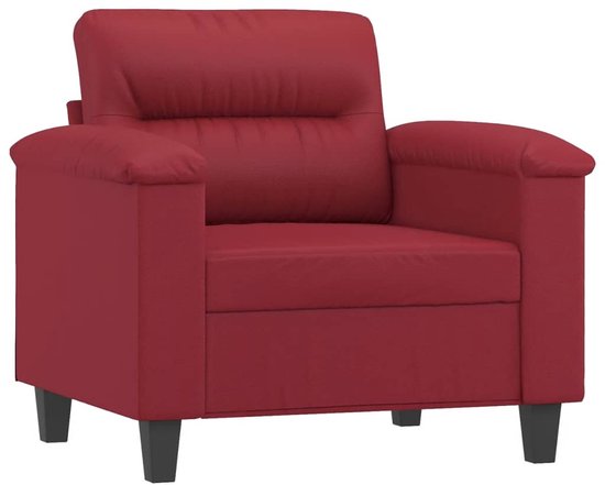 Fauteuil van wijnrood kunstleer in een hoekopstelling met zwarte poten.