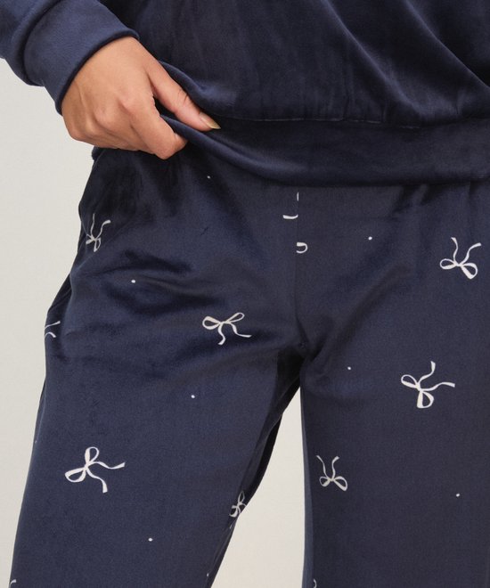 Detail van de donkerblauwe velours pyjamabroek met strikje print.