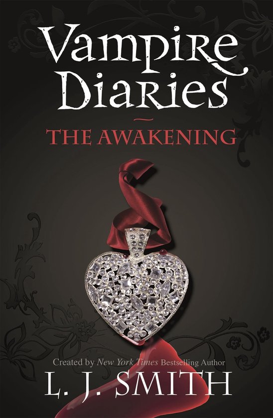 Boekomslag: Vampire Diaries: The Awakening, met een hartvormige hanger vol kristallen en een rode strik.