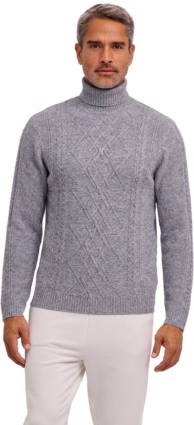 Model draagt een grijze FALKE coltrui met kabelpatroon, gecombineerd met een witte broek.