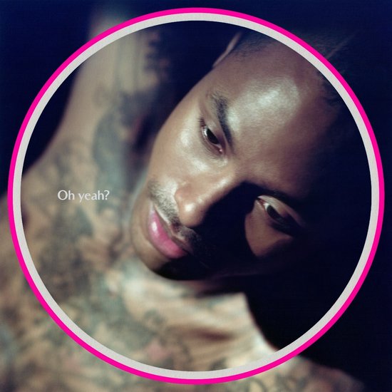 Close-up van een man met tatoeages, met de tekst "Oh yeah?"