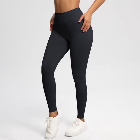 Zwarte sportlegging met hoge taille en witte sneakers, zijaanzicht.
