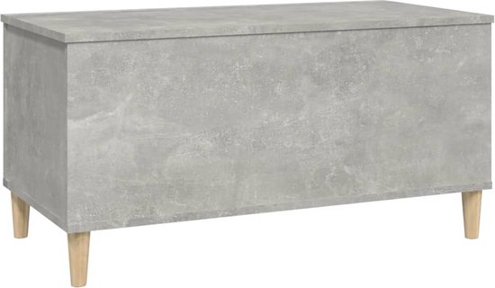 Gesloten betongrijze salontafel met vier schuine houten pootjes.