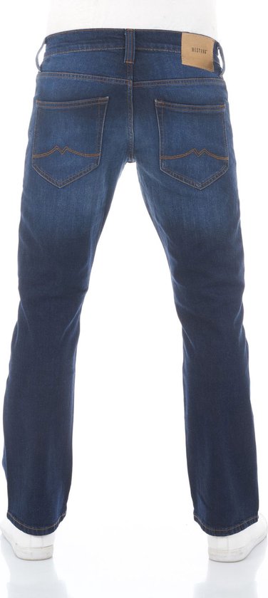 Man met de rug naar de camera, draagt een donkerblauwe jeans met oranje stiksels.