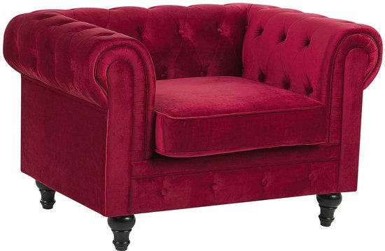 Donkerrode fluwelen chesterfield fauteuil met knopen en zwarte pootjes.