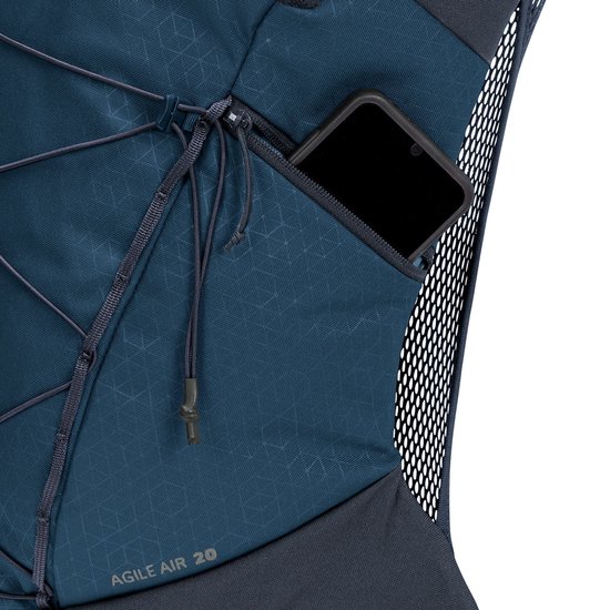 Close-up van een donkerblauwe VAUDE rugzak met een telefoon in een ritsvak en "AGILE AIR 20" tekst.