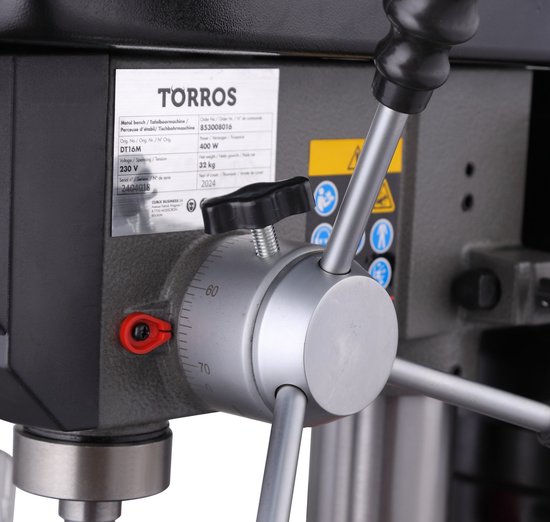 Grijze boormachine met typeplaatje, zilveren hendels en schaalverdeling met getallen 60 en 70.