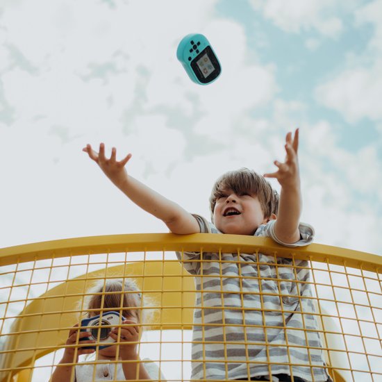 Kinderen gooien cyaan KidyWolf Kidycam in de lucht.
