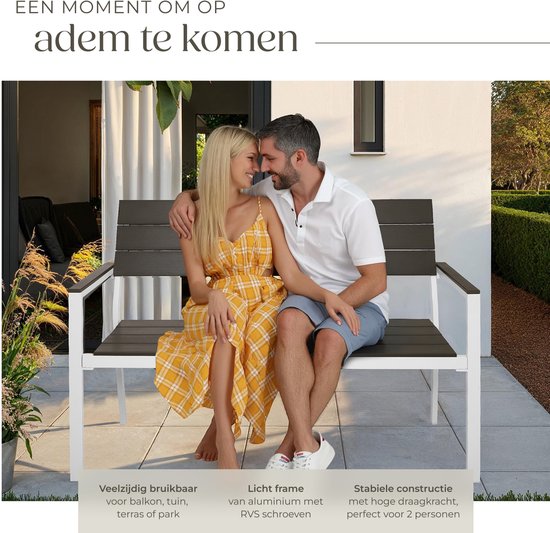Een koppel op een donkerbruine tuinbank met wit frame, zittend op een terras.