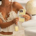 Telefoonhoesje met gele en witte strepen en een "Lemonade" etiket. Een model houdt het hoesje vast naast een bijpassend hoesje voor oordopjes.