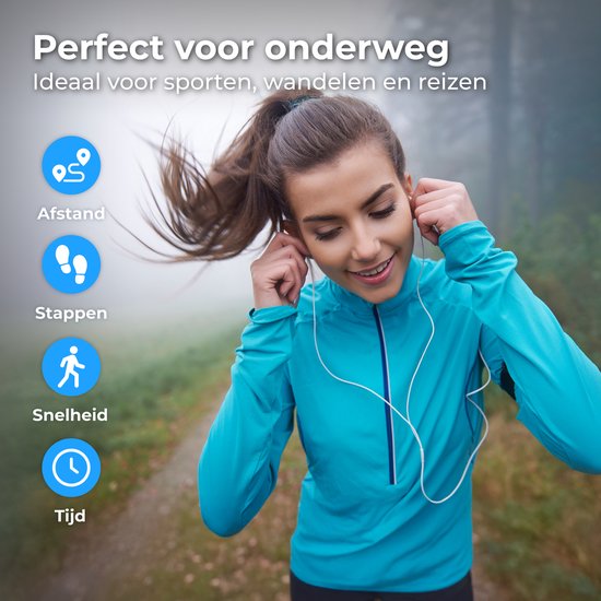 Vrouw in een blauw sportjack met oordopjes, luisterend naar muziek tijdens het wandelen in een mistig bos.