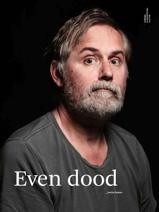 Man met grijzend haar en baard draagt een grijs T-shirt. Tekst: Even dood.
