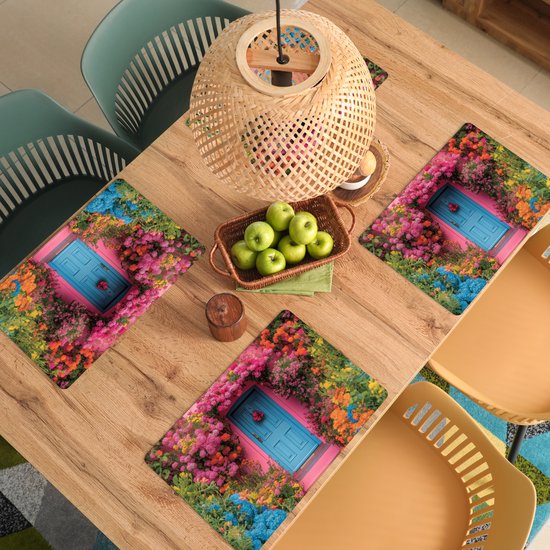 Sets de table avec un imprimé d'une maison rose avec une porte bleue, entourée de fleurs et de plantes colorées.