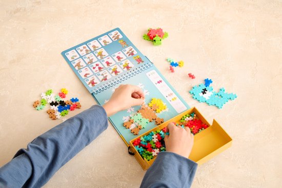 Handen bouwen met Plus-Plus stenen, met instructies voor een hert en zeeleven. Inclusief veel gekleurde stenen.