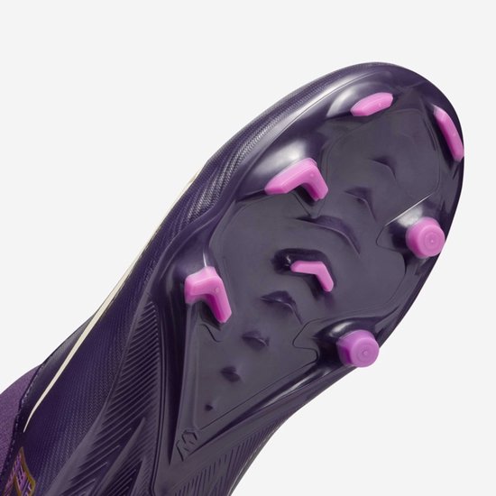 Close-up van de zool van een paarse voetbalschoen met roze noppen.