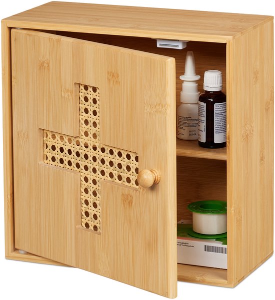 Open houten medicijnkastje van bamboe met een kruisvormig raster van rotan op de deur. De kast bevat medicijnen.