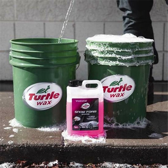 Fles Turtle Wax Snow Foam Shampoo naast twee groene emmers met schuim.