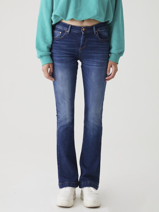 Model in een donkerblauwe, licht uitlopende jeans en een turquoise cropped hoodie.