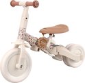 Crèmekleurige loopfiets met bruine zitting en handvatten. Het frame is versierd met een bloemenprint.
