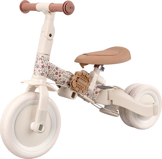 Crèmekleurige loopfiets met bruine zitting en handvatten. Het frame is versierd met een bloemenprint.