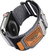 Grijze stoffen horlogeband met bruin 'Outdoor Sports' label en oranje lusje, bevestigd aan een Apple Watch.
