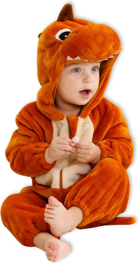 Een jong kind in een bruine dinosaurus onesie met open mond, zittend.