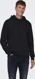 Man met bruine haren draagt een zwarte hoodie met capuchon, hand in de zak.