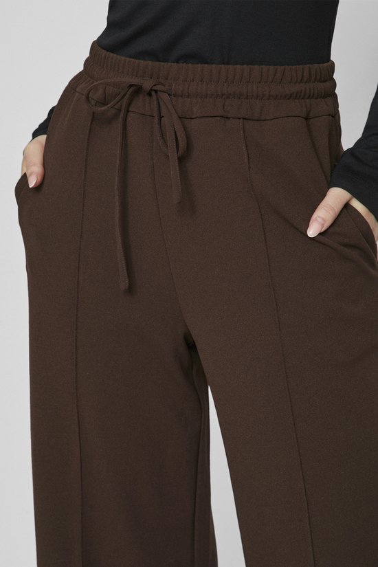 Bruine broek met elastische tailleband, trekkoord en steekzakken.