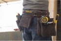 Gereedschapsgordel van Stanley met rolmaat en gereedschap, gedragen door een man.