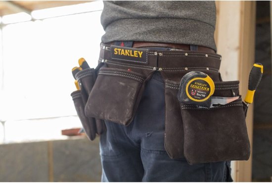 Gereedschapsgordel van Stanley met rolmaat en gereedschap, gedragen door een man.
