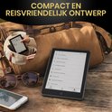 E-reader en zonnebril naast een tas, met een iPhone en een kop koffie.