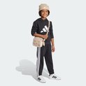 Jongen met een beige teddy tasje in de vorm van een schaapje, draagt een zwarte hoodie en broek.