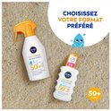 Twee NIVEA SUN babies & kids sensitive protect flacons op zand. Grote sprayflacon en kleinere tube. Tekst 'CHOISISSEZ VOTRE FORMAT PRÉFÉRÉ'.