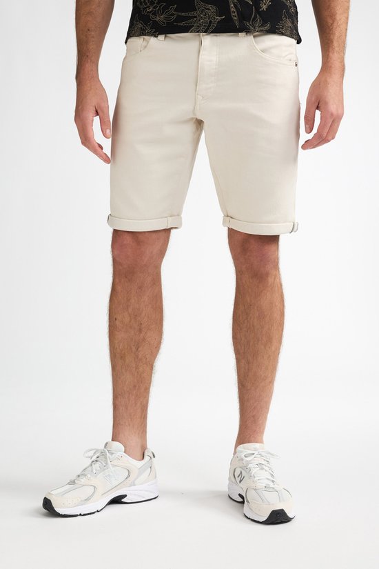 Man in beige shorts en witte sneakers, vooraanzicht.