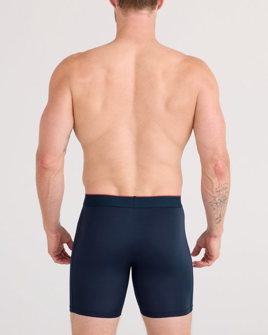 Man van achteren gezien, draagt donkerblauwe SAXX boxer briefs.