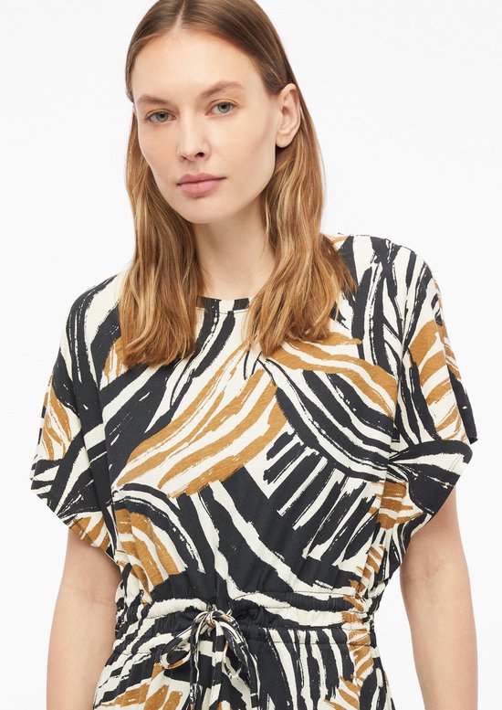 Gedetailleerde close-up van een jurk met grafische print in zwart, wit en bruin.
