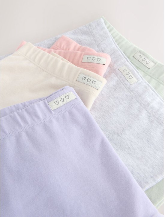 Close-up van 5 opgevouwen zachte shorty's in diverse pastelkleuren met hartjeslabel.