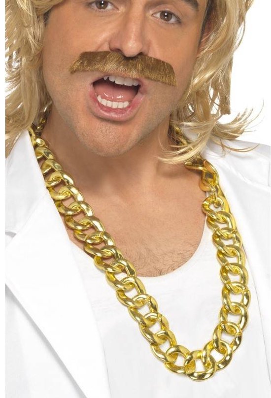 Man met blonde pruik, snor en witte jas draagt een dikke gouden ketting.