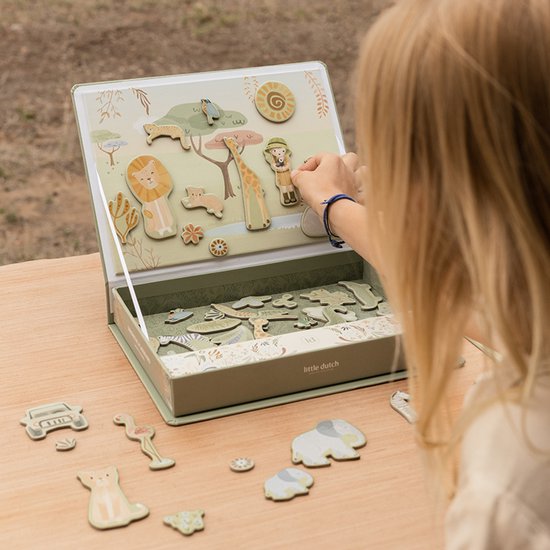 Meisje speelt met magnetisch safari speelbord, met dieren zoals leeuw, giraf, zebra en olifant.