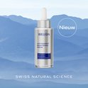 Weleda Anti-Pigment Brightening Serum in zilveren fles met druppelaar, met tekst 'Nieuw' en bergen op achtergrond.